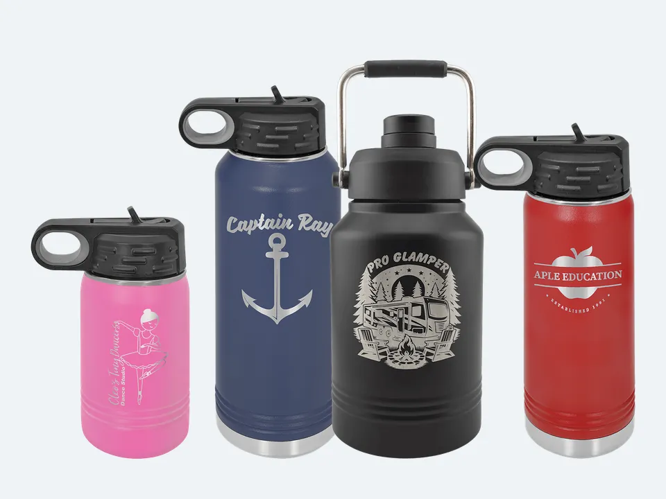 Four Polar Camel bottles with sample engravings: a pink 12 oz water bottle, a navy 32 oz water bottle, a black 64 oz jug with a carry handle and a red 20 oz water bottle