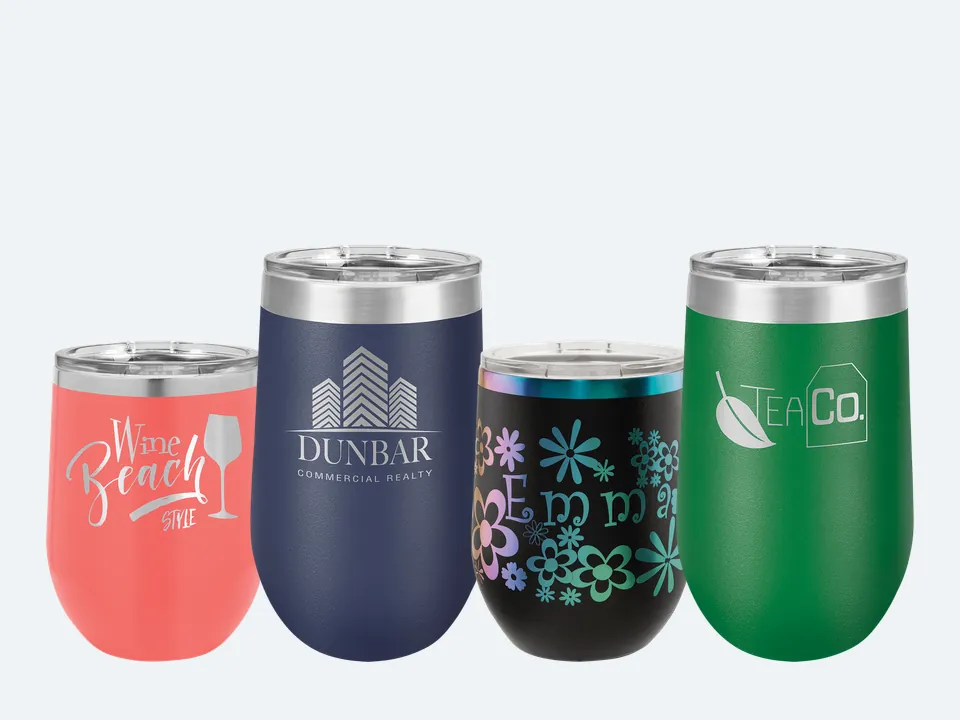 Four Polar Camel stemless tumblers with sample engravings: a coral 12 oz wine tumbler, a navy 16 oz wine tumbler, a black prism 12 oz wine tumbler and a green 16 oz stemless tumbler