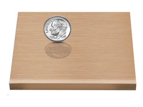 A brushed bronze sample plate, with a dime on it for scale