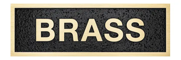 A sample plaque with the word BRASS in raised brass letters on a black textured background