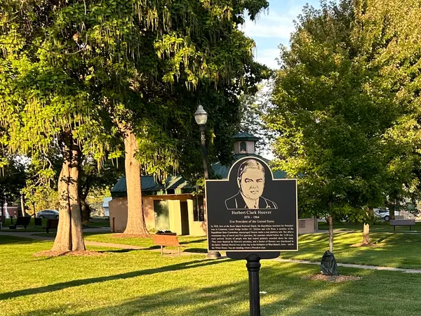 An example of a historical marker with a portrait, on a post in a town park