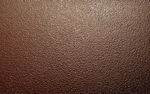 A close up of the sand background texture on a bronze plaque