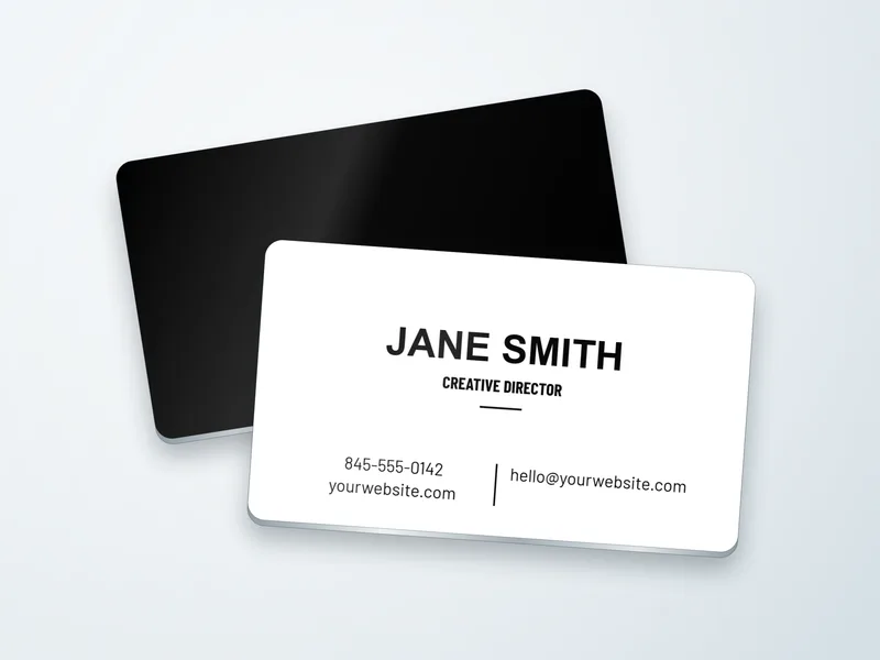 Two metal business cards in white-coated aluminum with rounded corners, a white front with a black name over its solid black back, the metal showing at the edges